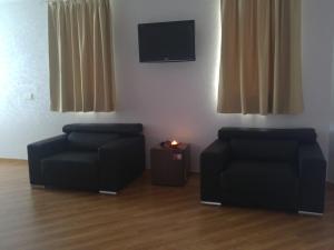 a living room with two chairs and a tv at Hotel Gardu in Montealegre del Castillo