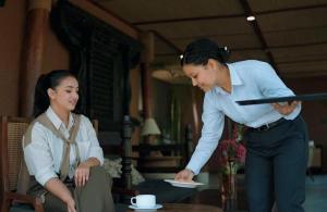 a woman pointing at a plate in a movie at Miraaya Wellness and Golf Resort in Kawasoti +74 photos