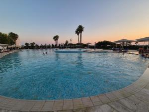 a large pool with blue water in a resort at Beach House Lleshi in Tale