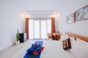 a bedroom with a bed and a desk and a window at Bali intan Canggu in Canggu +17 photos