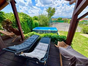 a porch with two chairs and two loungers on it at Pensiunea Carmen - Bikers Friendly Nest in Sibiu