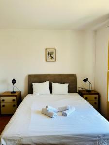 a bedroom with a bed with two towels on it at PHOS - Pag Residences in Kustići