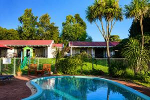 a house with a swimming pool in the yard at Karri Forest Motel in Pemberton