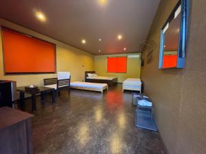 a room with two beds and tables and a room with a bed at スパイス平戸 in Hirado