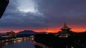a view of a river at sunset with a building at Riverbank 904 in Kuching