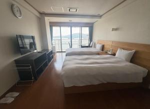 a hotel room with two beds and a television at ウェルカムイン松島 in Matsushima
