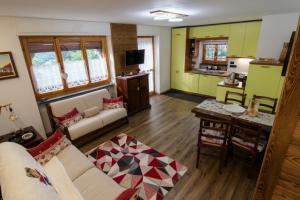 a living room with a couch and a kitchen at Chalet La Cometa in Sauze dʼOulx