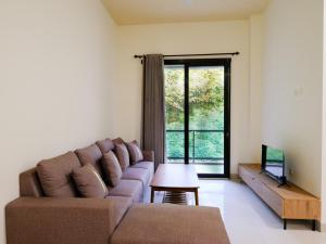a living room with a couch and a tv at Apatto Bajo in Labuan Bajo