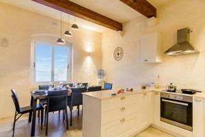 a kitchen and dining room with a table and chairs at Inni Gozitan Farmhouse Private Pool- Happy Rentals in Santu Pietru