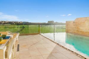 a patio with a pool and a table and chairs at Inni Gozitan Farmhouse Private Pool- Happy Rentals in Santu Pietru +28 photos