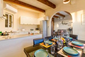 a dining room with a table and a kitchen at Inni Gozitan Farmhouse Private Pool- Happy Rentals in Santu Pietru