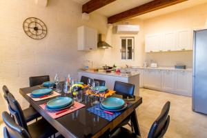 a dining room with a table and chairs and a kitchen at Inni Gozitan Farmhouse Private Pool- Happy Rentals in Santu Pietru
