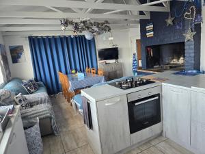 a kitchen and living room with a stove top oven at SONVANGER VILLA YZERFONTEIN in Yzerfontein +20 photos
