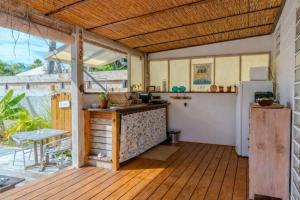 an outdoor kitchen with a counter and a refrigerator at Breeze Ocean Bungalow Moorea in Moorea