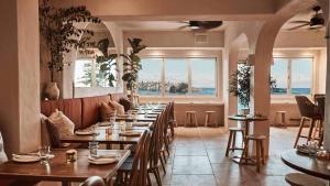 a restaurant with wooden tables and chairs and a window at Bondi Beach Escape, Steps to Sand & Cafe in Sydney