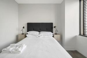 a bedroom with a white bed with towels on it at Bondi Beach Escape, Steps to Sand & Cafe in Sydney