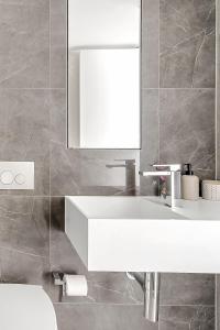 a bathroom with a white sink and a mirror at Bondi Beach Escape, Steps to Sand & Cafe in Sydney +29 photos