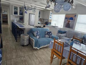 a living room with a blue couch and a kitchen at SONVANGER VILLA YZERFONTEIN in Yzerfontein