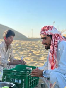 two men sitting next to a green crate at Rumis Jaisalmer in Jaisalmer