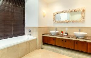 a bathroom with two sinks and a tub and a mirror at Village du Pecheur in Baie Sainte Anne +76 photos