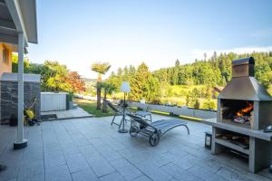 a patio with a grill and a pizza oven at Residenza San Remy Hundefreundliche Ferienwohnung mit Whirlpool in Unterkulm