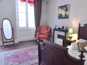 a bedroom with a bed and a chair and a fireplace at Maison du Magnolia in Confolens