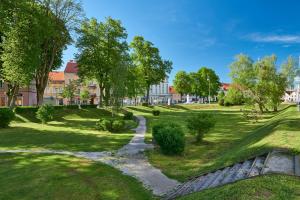 a pathway through a park with trees and a building at Feels like home in Karlovac