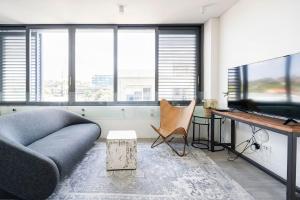 a living room with a couch and a table and a television at Cozy Bondi Apartment Heated Winter Stay in Sydney