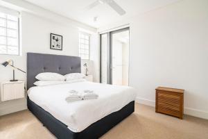 a bedroom with a large bed with two towels on it at Cozy Bondi Apartment Heated Winter Stay in Sydney