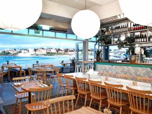 a restaurant with tables and chairs and a view of the water at Cozy Bondi Apartment Heated Winter Stay in Sydney