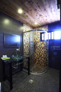ein Bad mit einer Glasdusche und einem Waschbecken in der Unterkunft Sung-Ding Guesthouse in Jian