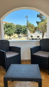 two chairs and a table in front of a window at Sole e Luna in San Vito