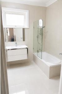 a bathroom with a tub and a sink and a shower at Light-Filled Modern Home 3BR Pet-Friendly 5km-CBD in Perth +26 photos