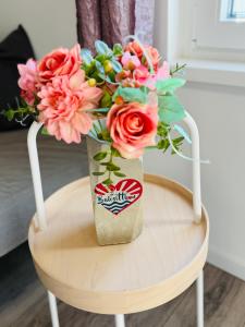 a bouquet of flowers in a soda can on a chair at Balcsitthon Apartmanok in Siófok