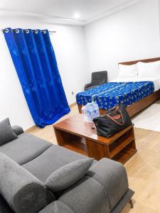 a room with a bed and a couch and a table at TchaoPremium in Lomé +9 photos