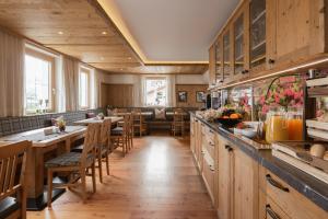 a restaurant with wooden floors and wooden tables and chairs at Apart Hotel Garni Kofler in Fiss