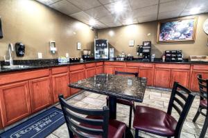 a bar with a table and chairs in a restaurant at Rodeway Inn Medford South I-5 in Medford