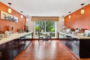 a kitchen with orange walls and a table with chairs at Sleep Inn Beaufort near MCAS in Beaufort