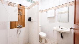 a white bathroom with a toilet and a sink at Cemara Asri Guesthouse in Lembang +16 photos