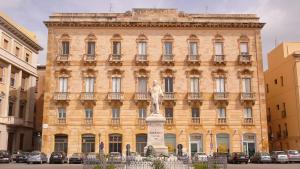 a large building with a statue in front of it at Zahir Rooms & Wellness srls in Trapani
