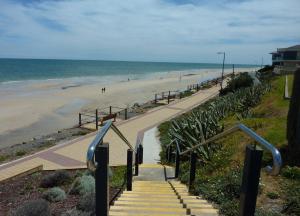 a stairway leading to a beach with people walking on it at Seaside Adelaide Holiday Apartment 2BR 1 min walk to Brighton Beach in Adelaide