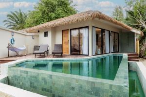 a villa with a swimming pool in front of a house at Samaraya Wellness Resort - Adults Only in Lipa Noi