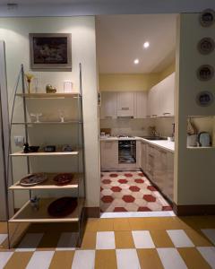 a kitchen with white cabinets and a checkered floor at A Palazzo Busdraghi Residenza D'Epoca in Lucca