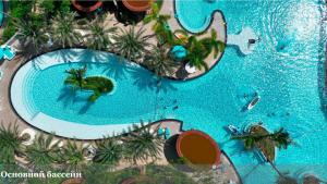 an overhead view of a large swimming pool with palm trees at Vaperse Hainan Clear Water Bay in Lingshui