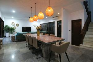 a dining room with a wooden table and chairs at Villa Yasmin in Seminyak