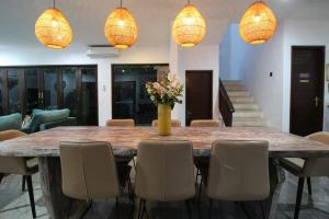 a large dining room table with chairs and lights at Villa Yasmin in Seminyak
