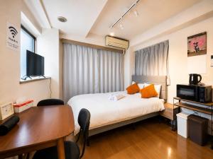 a hotel room with a bed and a desk and a table at Ichigaya Stay & Wi-Fi 1 in Tokyo
