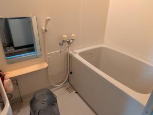 a small bathroom with a tub and a mirror at 牟礼ぐらし宿 in Takamatsu +16 photos