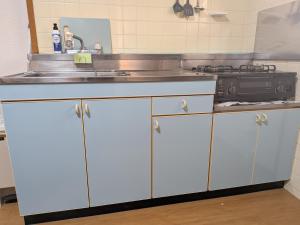 a kitchen with white cabinets and a sink at 牟礼ぐらし宿 in Takamatsu