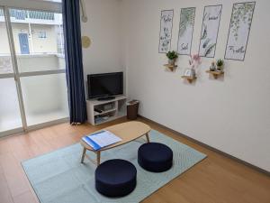 a living room with a table and a tv at 牟礼ぐらし宿 in Takamatsu